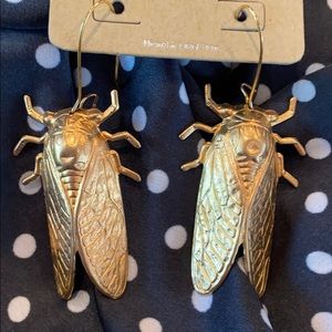 Dangling gold colored locust earrings